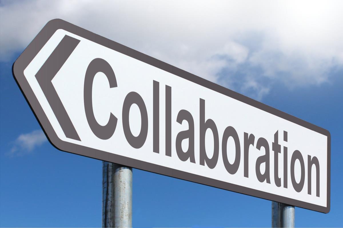 Panneau indiquant "Collaboration" sous un ciel bleu, symbolisant le travail d'équipe et le partenariat.