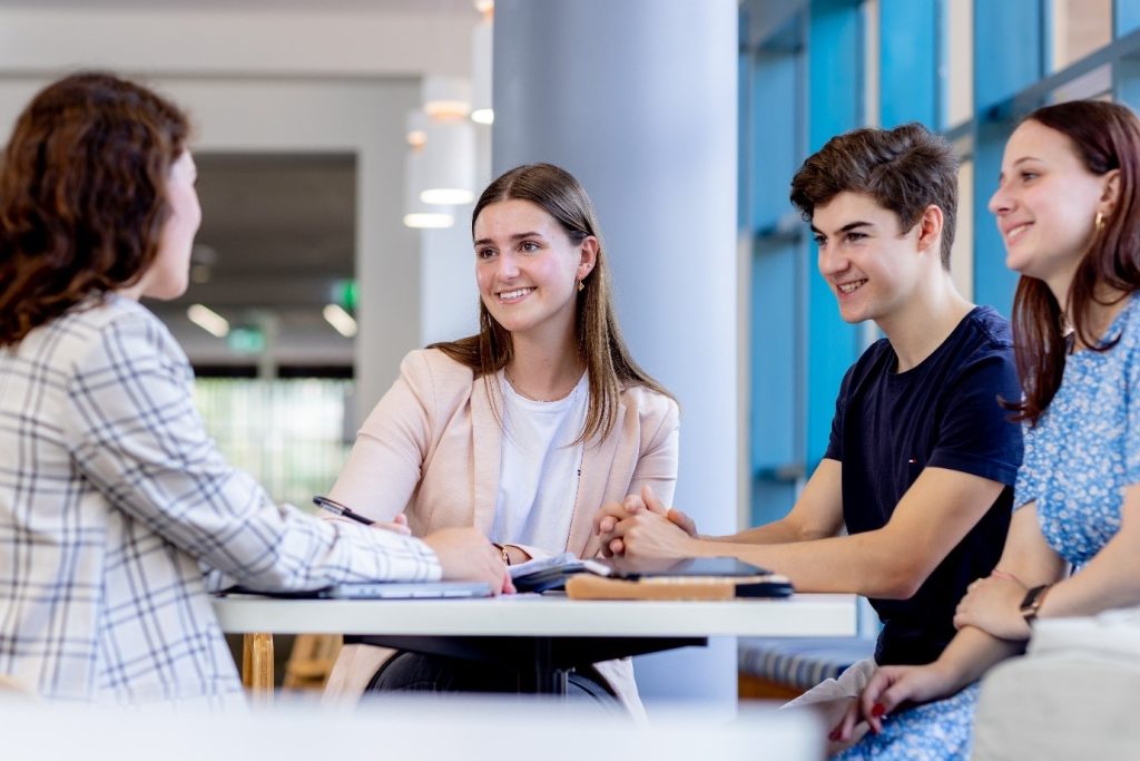 Étudiant, assis avec une équipe de recrutement, utilisant la méthode STAR lors d'un entretien d'embauche