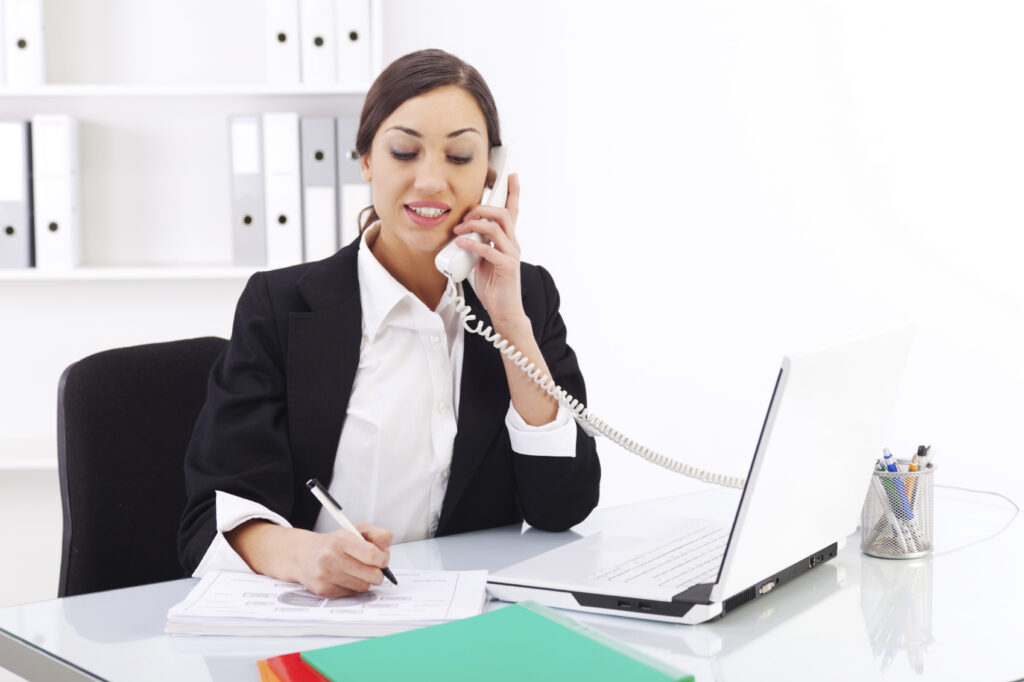 Personnel de recrutement posant des questions entretien téléphonique et prenant des notes.