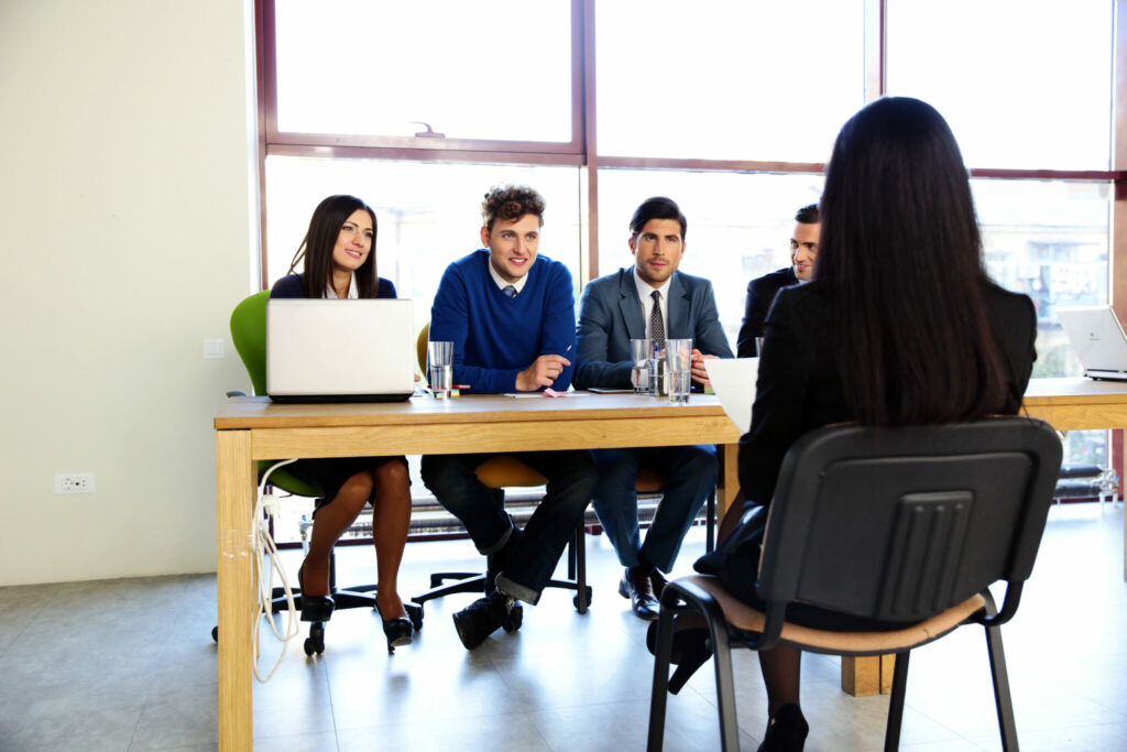 Étudiante assise devant l'équipe de recrutement, présentant son CV.